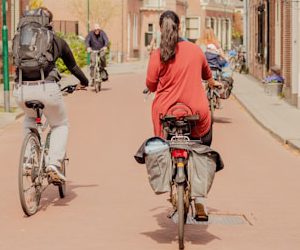 a couple of people riding bikes down a street