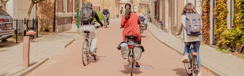 a couple of people riding bikes down a street