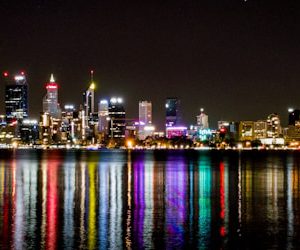 city lights reflecting on harbor at nighttime