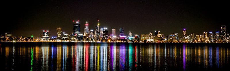 city lights reflecting on harbor at nighttime