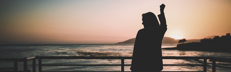 silhouette of woman standing near the fence