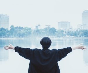 man in black jacket standing near body of water during daytime