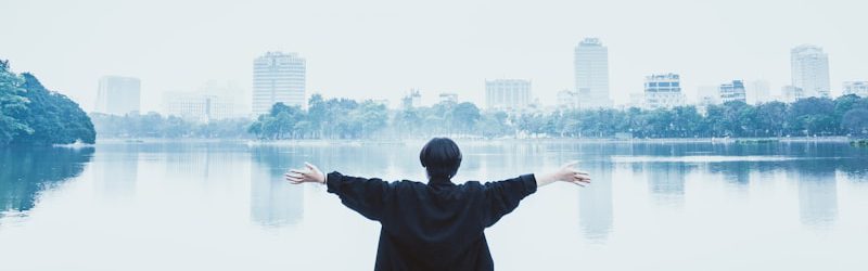 man in black jacket standing near body of water during daytime