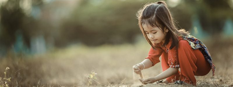 girl playing sand during daytime